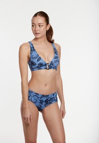 Modrý bikiny set obsahuje trojuholníkový top s predným zapínaním a čiernym kvetinovým vzorom, doplnený o zodpovedajúce vysoké spodné diely.