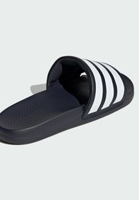 Námorné šľapky so štruktúrovanou čiernou podrážkou, polstrovanou stielkou a tromi bielymi pruhmi na vrchu. Ľahký a minimalistický dizajn.