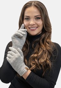 Grijze gebreide handschoenen met ribgebreide manchetten, gemaakt van zacht materiaal, met een merkembleem van bruin leer op de pols.