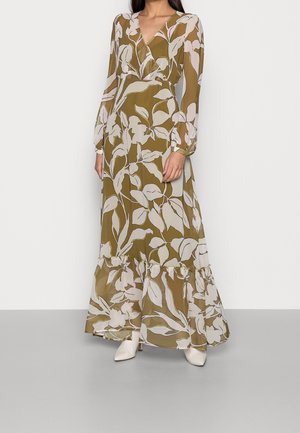 Maxiklänning i olivgrön med vitt blommönster, med långa ärmar, V-ringning och volang i fållen. Tillverkad i lätt tyg.