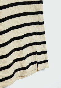 Tissu côtelé beige avec des rayures noires horizontales. Présente des fentes latérales, une surface texturée et un design décontracté pour le confort.