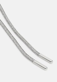 Skoelisser prydet med rhinestones i sølv, med en flettet design og metalliske aglets, som reflekterer lys med en teksturert finish.