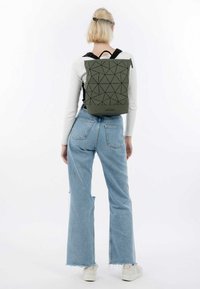 Zaino verde con motivo geometrico, di forma rettangolare, realizzato in materiale resistente e dotato di spallacci neri e di una maniglia superiore.