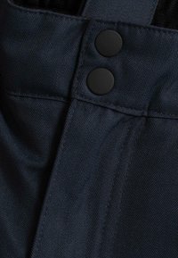 Tissu bleu marine avec un motif en chevrons, comportant deux boutons noirs en haut et une finition texturée.