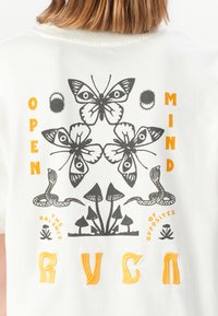 White shirt back with black butterfly, snake, and mushroom illustrations, orange text reading "OPEN MIND" and "RVCA" embroidered below.