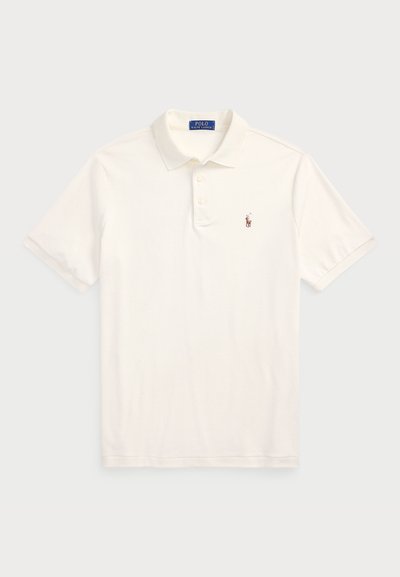 Polo de manga corta en algodón crema, con cuello, tres botones y un pequeño logo bordado en el lado izquierdo del pecho.