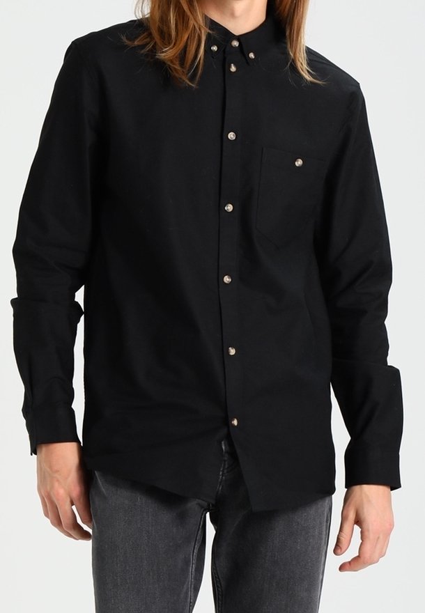 Zwarte button-up shirt gemaakt van katoen, met een klassieke kraag, een zak aan de linkerkant en zilverkleurige knopen. Lange mouwen met manchetten.