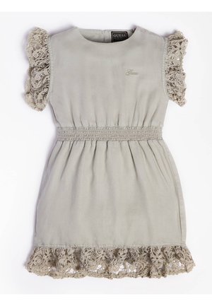 Robe beige clair sans manches avec volants en dentelle aux manches et à l'ourlet, taille élastiquée froncée et petit logo Guess brodé sur la poitrine.