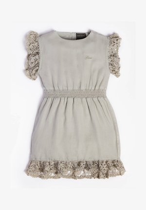Lyse beige ærmeløs kjole med blondevolanter på ærmer og kant, elastisk gathered talje og lille broderet Guess-logo på brystet.