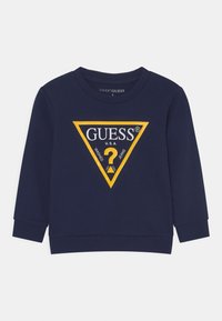 Felpa a maniche lunghe blu navy con polsini a costine, dotata di un grande logo triangolare giallo e testo "GUESS U.S.A." sul davanti.