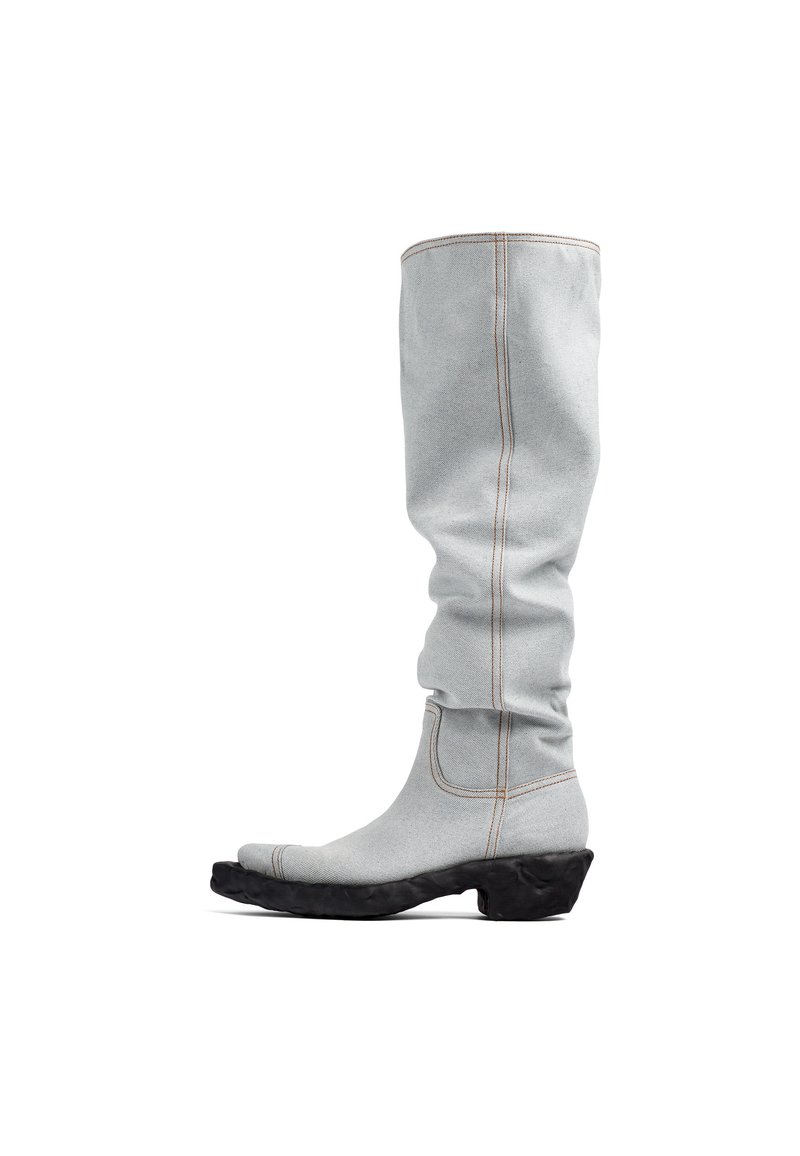 Botas de tela gris hasta la rodilla con una suela contrastante negra texturizada, costuras definidas y una forma de punta alargada.