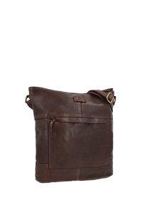 Borsa a spalla in pelle marrone con una texture morbida, cinturino singolo regolabile e tasca con zip anteriore. Presenta un design minimalista e un logo.