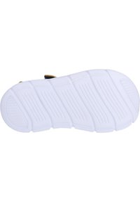 Valkoinen kumipohja kengällä, jossa on pystysuorat urat ja teksturoituja kuvioita, pyöristetty varvas ja vahvistetut pintamateriaalit.