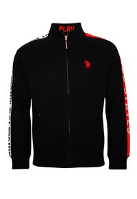 Veste zippée noire avec col montant. Présente des accents rouges sur les épaules, des bandes latérales blanches avec du texte, et un logo rouge sur la poitrine.