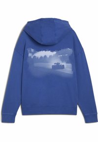 Plava dukserica s kapuljačom s velikim, izbjeljenim grafičkim motivom trkaćeg automobila na leđima. Tkanina izgleda mekano, s klasičnim krojem i rebrastim manžetama.