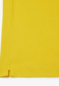 Tessuto giallo brillante con una superficie liscia, caratterizzato da un bordo dritto e una piccola fessura nell'angolo inferiore.