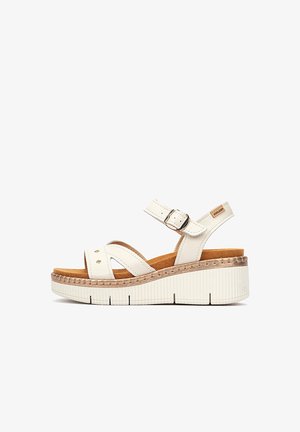 Sandalia de cuña blanca de cuero con correa ajustable en el tobillo, suela resistente y diseño de punta abierta.