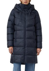 Manteau matelassé bleu marine avec capuche, présentant des coutures horizontales, des cordons élastiques, des poches zippées et une fermeture éclair frontale.