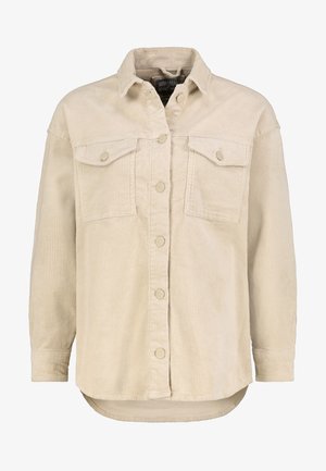 Beige fløjlsjakke med knapper foran, to brystlommer med klapper, lange ærmer, krave og en let buet kant.