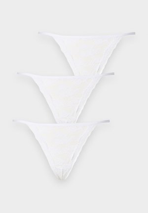 Conjunto de ropa interior de encaje blanco de tres piezas. Presenta un patrón floral, tirantes finos y una textura semitransparente.