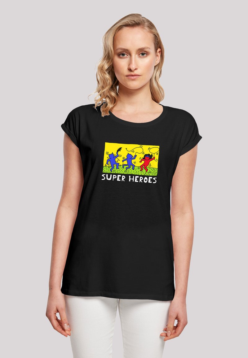 Black t-shirt with short rolled sleeves featuring a colorful graphic of four superheroes on a yellow background, text "SUPER HEROES" below.