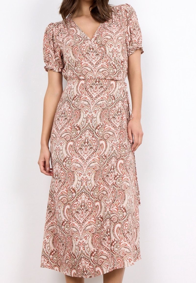 Femme portant une robe portefeuille à motifs cachemire floraux rose et beige arrivant aux genoux, avec des manches courtes bouffantes et un décolleté en V.