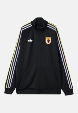 Jachetă sport neagră cu fermoar, cu dungi multicolore pe mâneci, logo Adidas pe pieptul stâng și un patch brodat colorat pe pieptul drept.