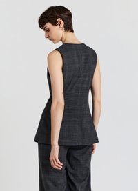 Top senza maniche grigio scuro con design a peplum, caratterizzato da un sottile motivo a quadri e una finitura liscia. Senza chiusure o tasche visibili.