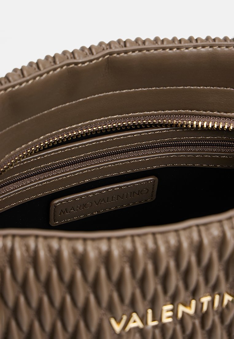 Sac à main en cuir brun texturé avec une poche intérieure zippée. Accents en doré avec une étiquette. Design structuré avec un motif matelassé.