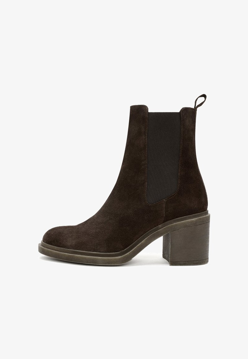 Bottine en cuir suédé marron avec des panneaux élastiques sur les côtés, un bout rond et un talon épais de hauteur intermédiaire avec une base texturée.
