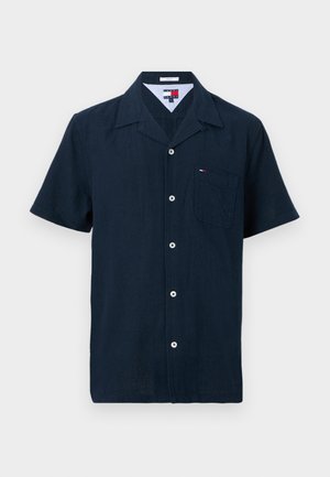 Camicia blu navy a maniche corte con bottoni, colletto a punta e taschino sul petto con piccolo logo a bandiera.