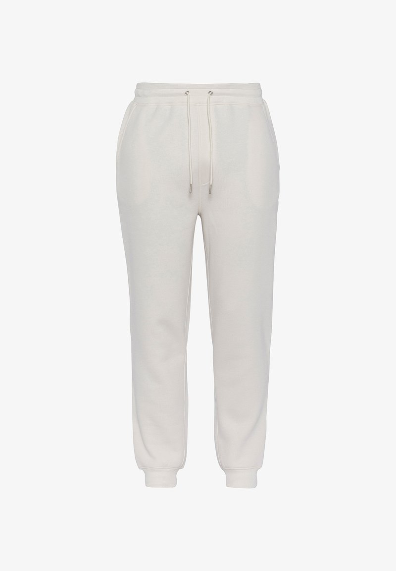 Lichtbeige sweatpants van zacht materiaal, met een elastische tailleband, trekkoord en taps toelopende boorden. Twee zijzakken zichtbaar.