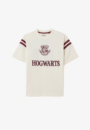 Cremfarbener Baumwoll-T-Shirt mit maroonfarbenem Hogwarts-Logo und -Schriftzug sowie maroonfarbenen Streifen an den Ärmeln. Kurzarm, lockere Passform.