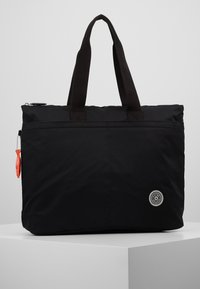 Sac fourre-tout en nylon noir avec deux poignées supérieures, fermeture éclair et patch logo circulaire, présentant une texture lisse et une forme rectangulaire.