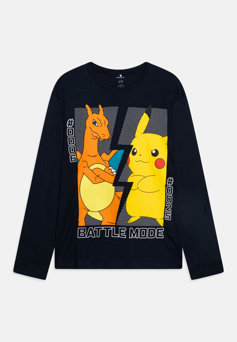 T-shirt à manches longues marine avec des graphiques colorés de Charizard et Pikachu, accompagné du texte "MODE COMBAT" et des numéros #006 et #025. Matière en coton.