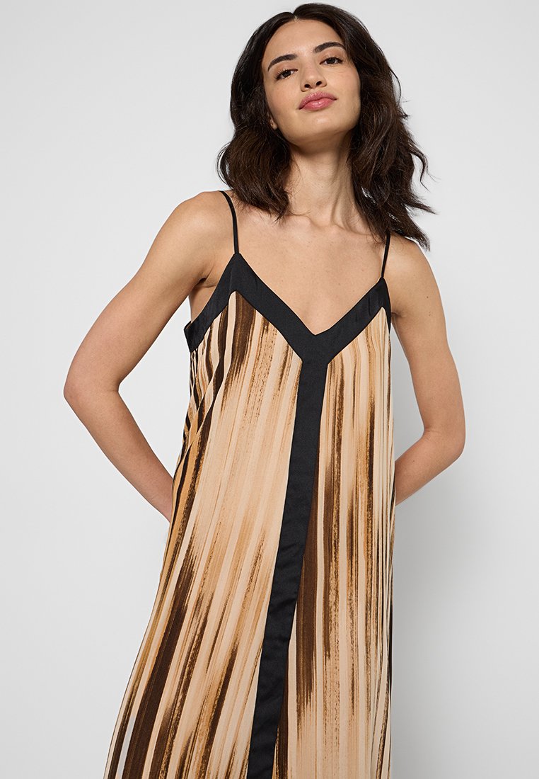 Luźna, bezrękawna sukienka z pionowymi beżowymi i brązowymi paskami oraz czarnym dekoltem w kształcie litery V i akcentami. Gładka tekstura materiału.