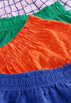 Színes pamut rövidnadrágok elasztikus derékpánttal. A jellemzők közé tartozik zöld, narancssárga pöttyös, valamint kék mintázat, egymásra rakva.