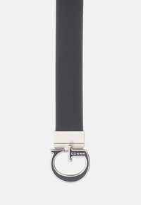 Ceinture noire texturée avec une boucle rectangulaire argentée élégante et des éléments circulaires ornés d'un détail logo.