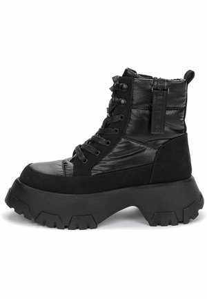Botte à plateforme noire à lacets avec dessus matelassé, semelle crantée épaisse, languette arrière à la cheville et détail de bride latérale.