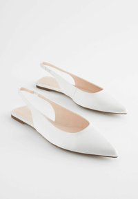 Valged slingback kortsed, terava toe, siled naha tekstuur, avatud kandmised, ja beež siseosa, mis esindavad minimalistlikku stiili.