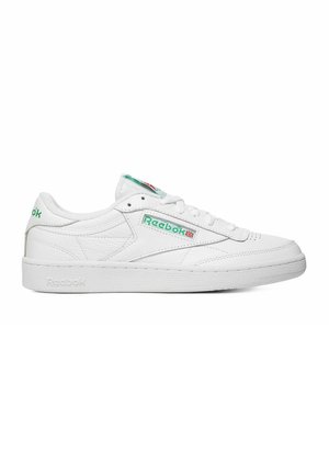 Białe, niskie sneakersy Reebok z zielonym logo i flagą Wielkiej Brytanii po boku, perforowany czubek i teksturowana podeszwa, pokazane z profilu.