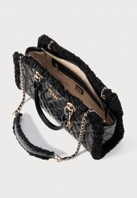 Borsa a tracolla nera trapuntata con hardware dorato, bordo in pelliccia nera, tracolla a catena e interno beige con tasca con cerniera, parzialmente aperta.