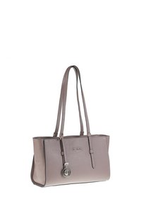 Sac cabas en cuir taupe avec double bandoulière et un charm circulaire en argent suspendu à une des bandoulières.