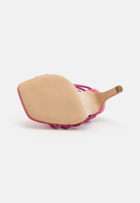 Roze hoge hak sandaal met een gestructureerd bandontwerp, open achterkant, gevoerde binnenzool en een gladde beige buitenzool. Hexagonaal teenvorm.