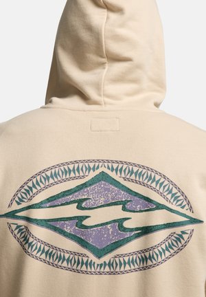 Felpa con cappuccio beige vista da dietro con un design a onde geometriche turchese e viola racchiuso in un motivo ovale decorativo.