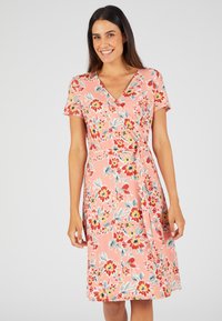 Vestido envolvente floral en color coral con mangas cortas, escote en V y cintura con lazo. Presenta un estampado floral multicolor y está confeccionado en una tela ligera.