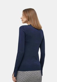 Maglione blu navy a maniche lunghe con scollatura rotonda. Presenta fessure laterali all'orlo, realizzato in tessuto a maglia morbido.