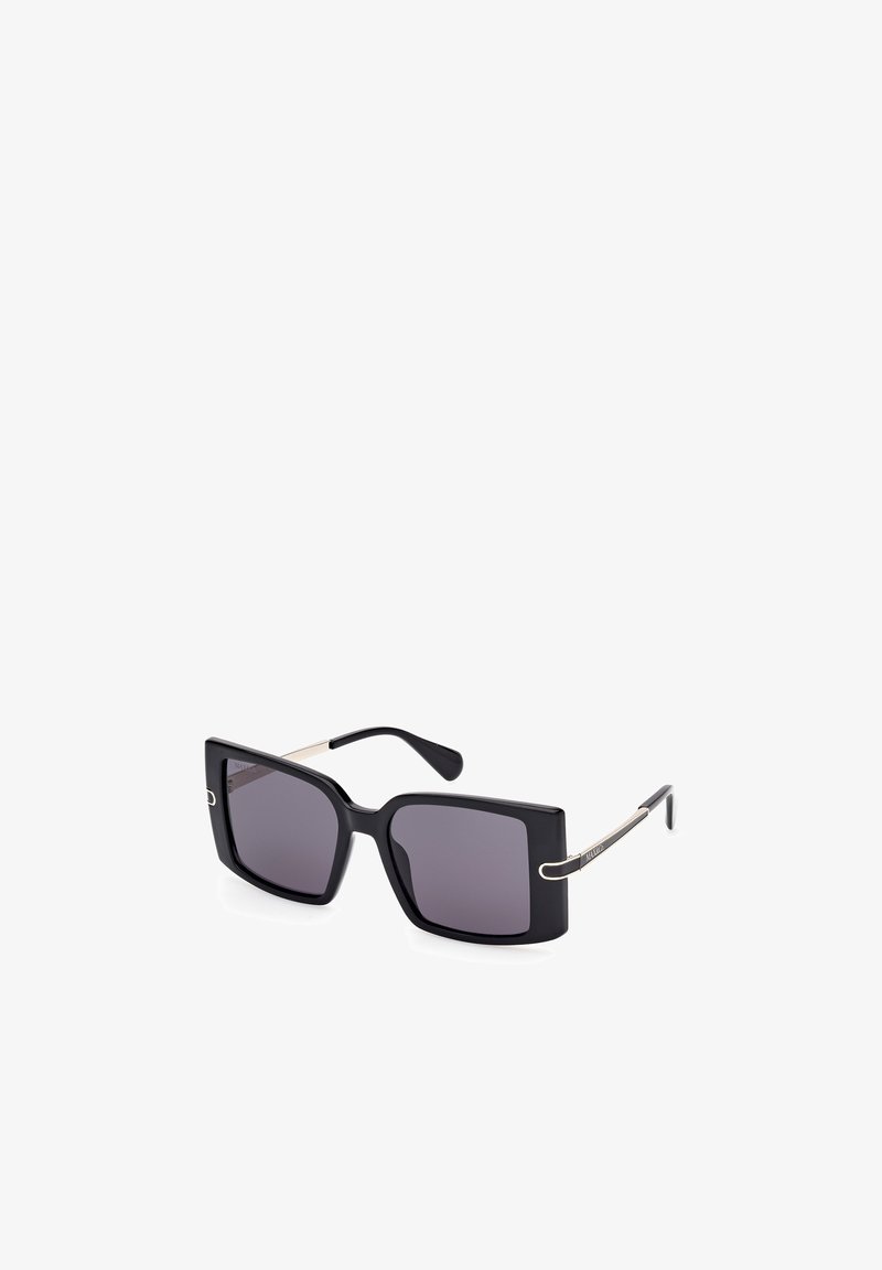 Gafas de sol cuadradas negras con lentes oscuros, que cuentan con un marco brillante y delgados acentos metálicos en las patillas, destacando un diseño moderno.