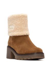 Stivale alla caviglia in suede marrone con un soffice risvolto in shearling beige, tacco chunky e suola testurizzata con un motivo di tasselli, caratterizzato da un dettaglio del logo.