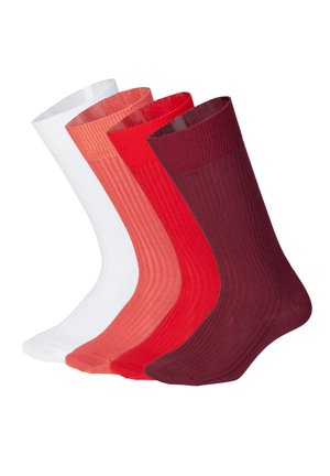 Quatre chaussettes montantes côtelées en blanc, corail, rouge et bordeaux, présentées côte à côte sur des formes transparentes sur fond blanc.